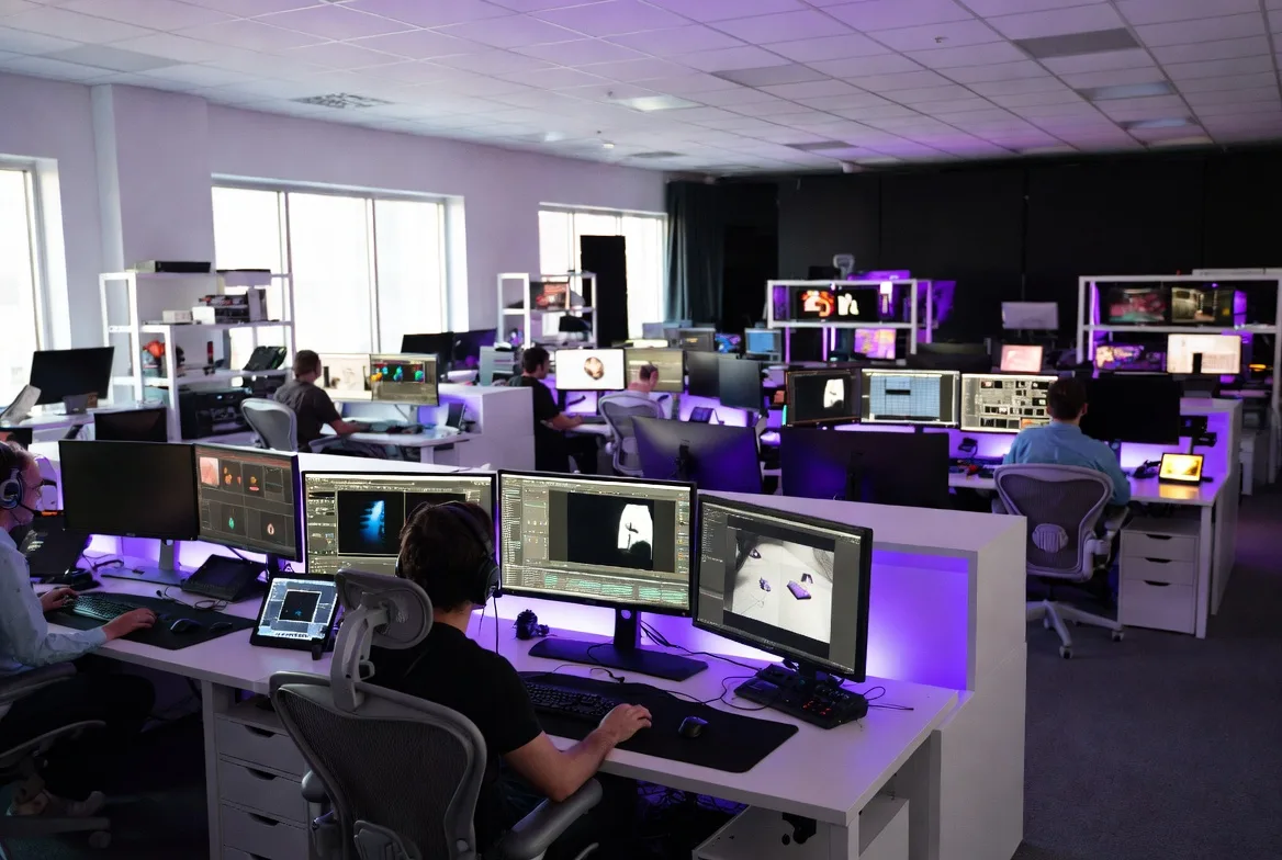 Editor at an Astra Visual Studios edit and colour grading suite, with reference monitors and posters of past projects